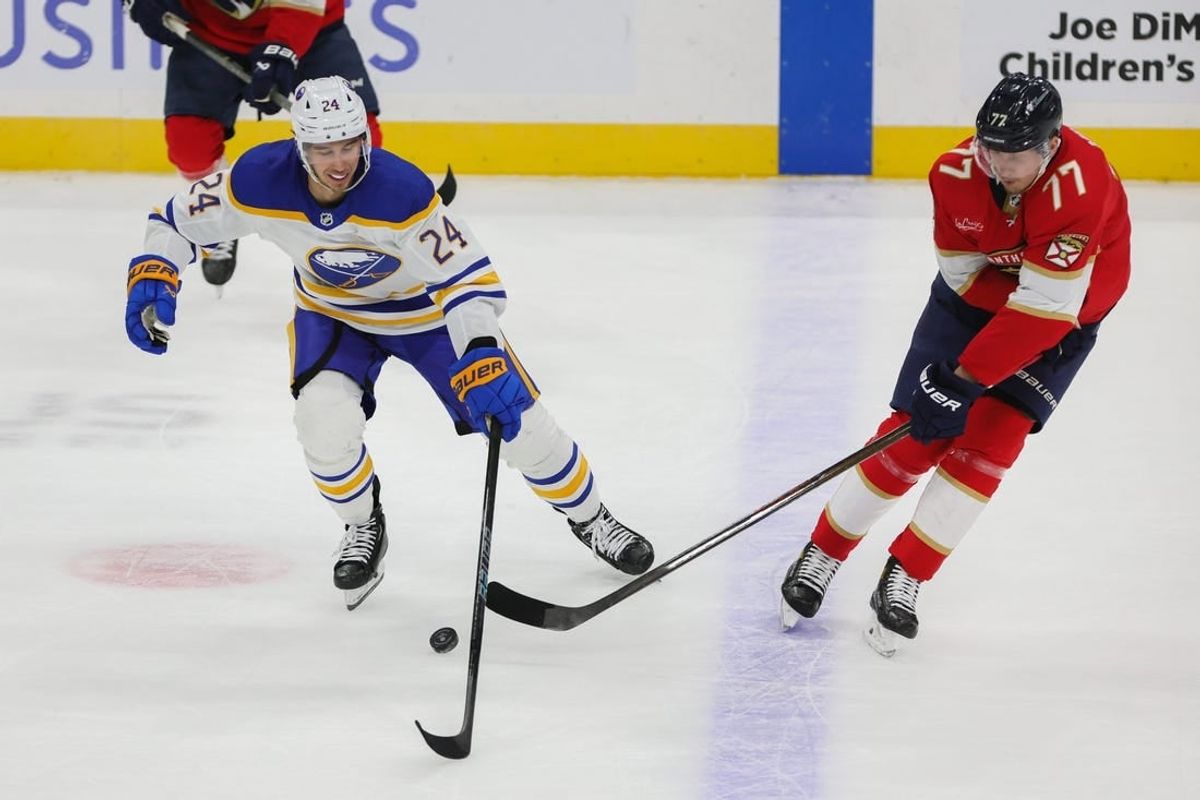 Feb 27, 2024; Sunrise, Florida, USA; Buffalo Sabres center Dylan Cozens (24) protects the puck from Florida Panthers defenseman Niko Mikkola (77) during the first period at Amerant Bank Arena.