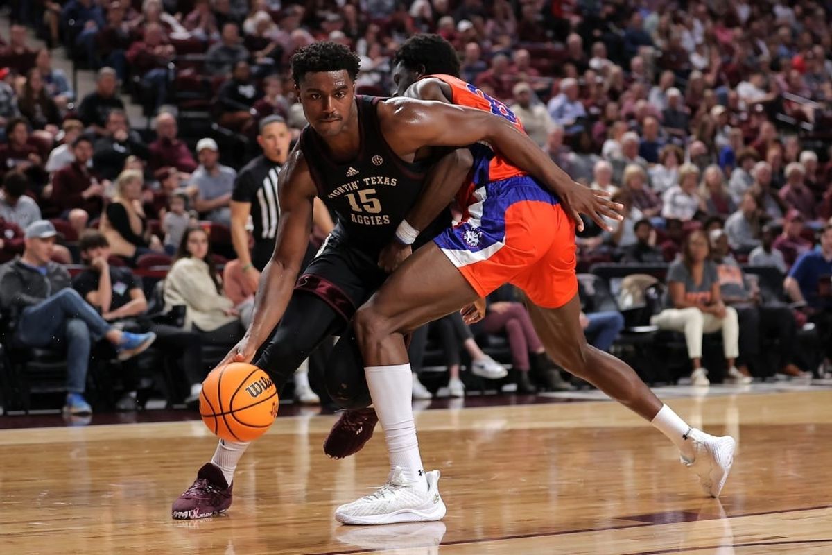 Dec 22, 2023; College Station, Texas, USA; Texas A&M Aggies forward Henry Coleman III (15) handles the ball inside against Houston Christian Huskies forward Chigozie Achara (20) during the first half at Reed Arena.