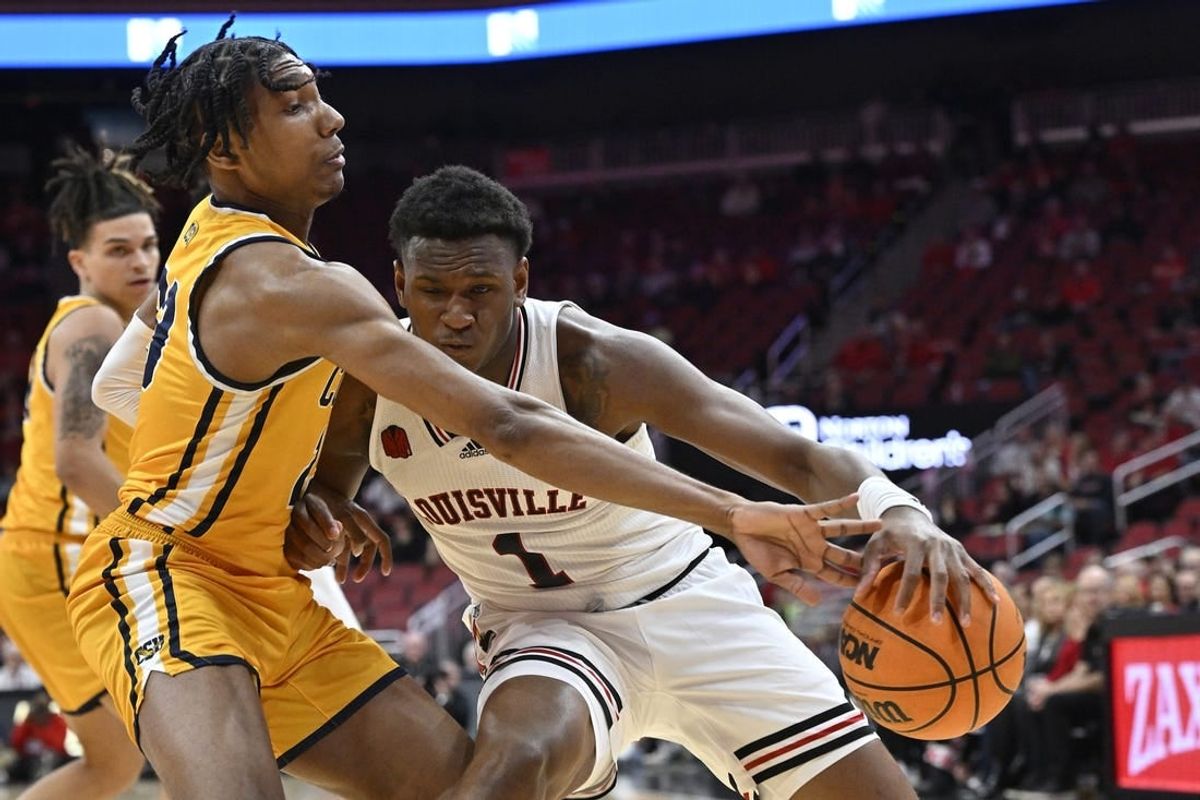 Nov 15, 2023; Louisville, Kentucky, USA; Coppin State Eagles guard Camaren Sparrow (23) pressures the dribble of Louisville Cardinals guard Curtis Williams (1) during the first half at KFC Yum! Center.