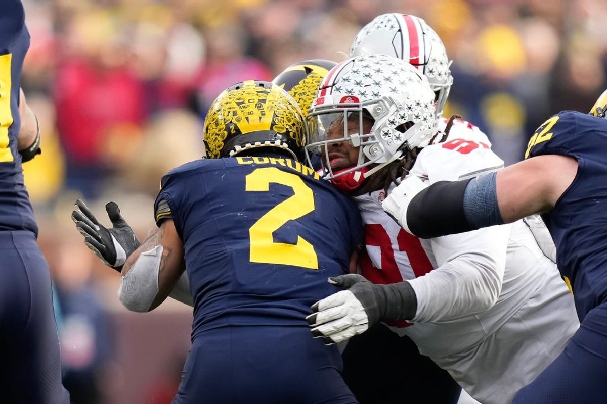 Nov 25, 2023; Ann Arbor, Michigan, USA; Ohio State Buckeyes defensive tackle Tyleik Williams (91) tackles Michigan Wolverines running back Blake Corum (2) during the NCAA football game at Michigan Stadium. Ohio State lost 30-24.