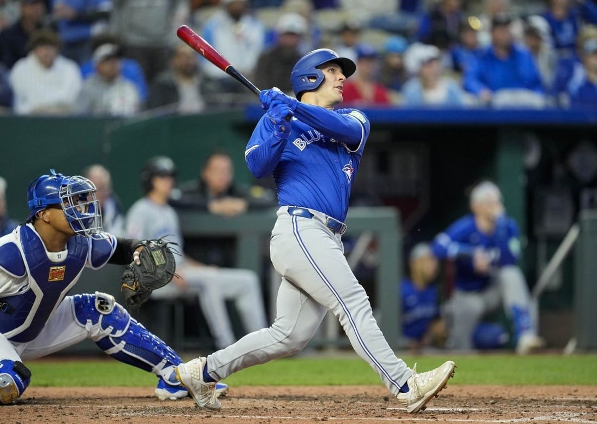 Apr 22, 2024; Kansas City, Missouri, USA; Toronto Blue Jays right fielder Daulton Varsho (25) hits a home run against the Kansas City Royals during the sixth inning at Kauffman Stadium.