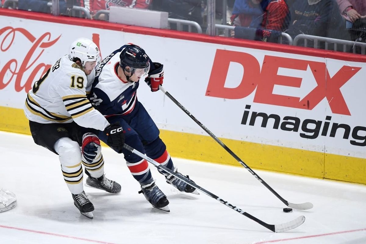 Mar 30, 2024; Washington, District of Columbia, USA; Washington Capitals defenseman John Carlson (74) controls the puck against Boston Bruins center John Beecher (19) during the third period at Capital One Arena.