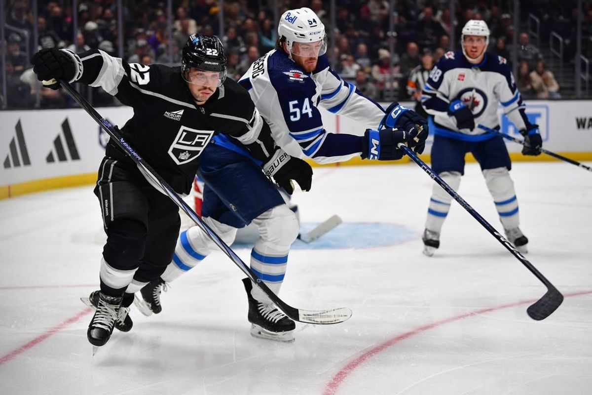 Dec 13, 2023; Los Angeles, California, USA; Los Angeles Kings left wing Kevin Fiala (22) plays for the puck against Winnipeg Jets defenseman Dylan Samberg (54) during the second period at Crypto.com Arena.