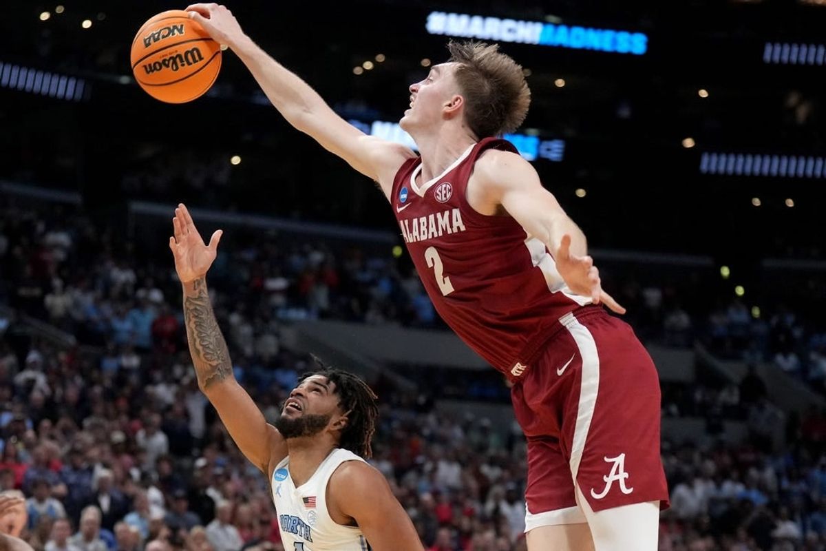 Mar 28, 2024; Los Angeles, CA, USA; Alabama Crimson Tide forward Grant Nelson (2) blocks North Carolina Tar Heels guard RJ Davis (4) in the second half in the semifinals of the West Regional of the 2024 NCAA Tournament at Crypto.com Arena.