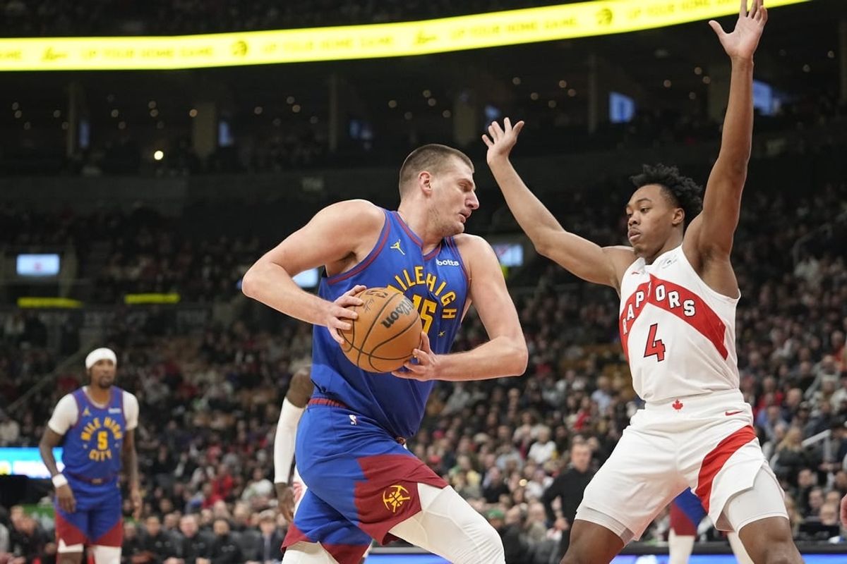 Dec 20, 2023; Toronto, Ontario, CAN; Denver Nuggets center Nikola Jokic (15) drives to the net against Toronto Raptors forward Scottie Barnes (4) during the first half at Scotiabank Arena.