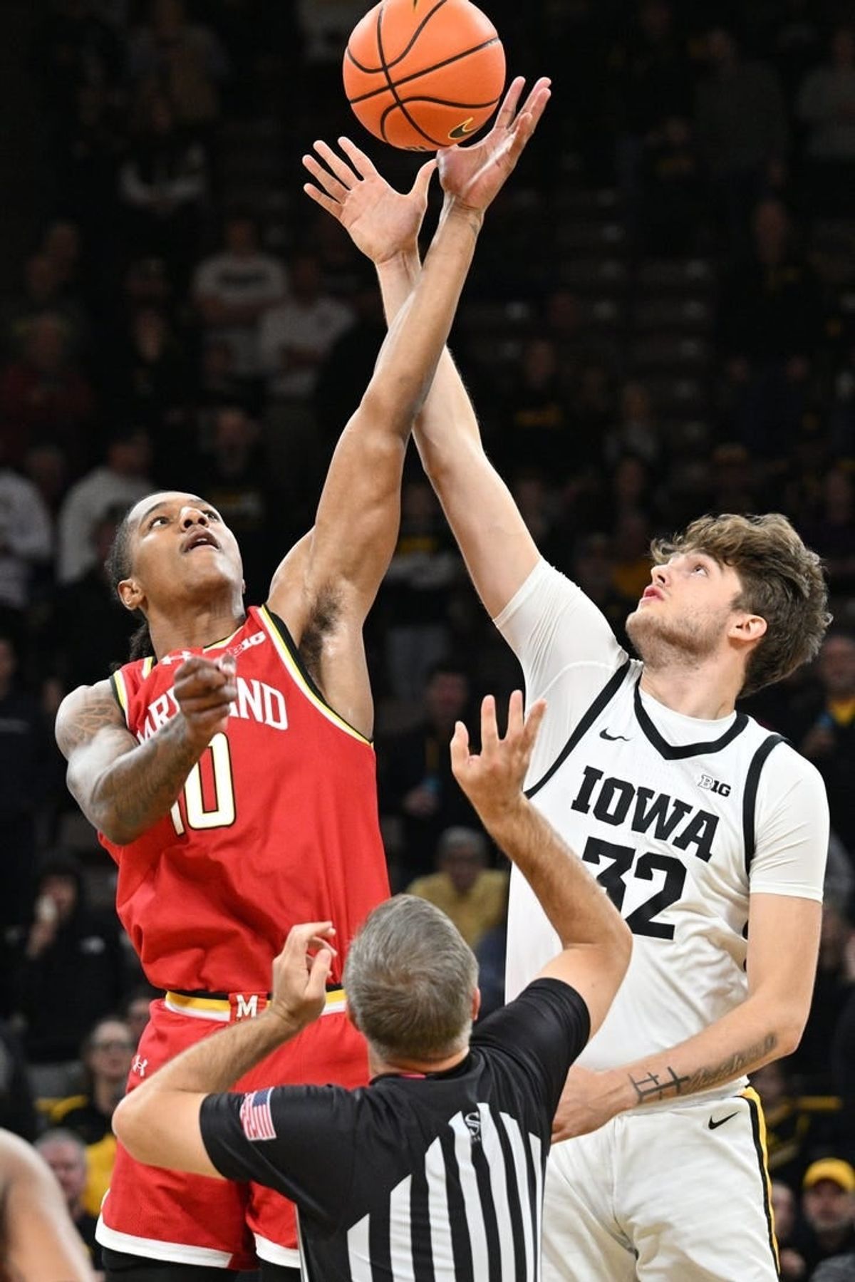 Jan 24, 2024; Iowa City, Iowa, USA; Iowa Hawkeyes forward Owen Freeman (32) and Maryland Terrapins forward Julian Reese (10) battle for the opening tipoff during the first half at Carver-Hawkeye Arena.