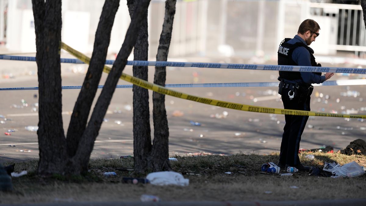 Law enforcement officers look around the scene after an incident following the Kansas City Chiefs victory parade