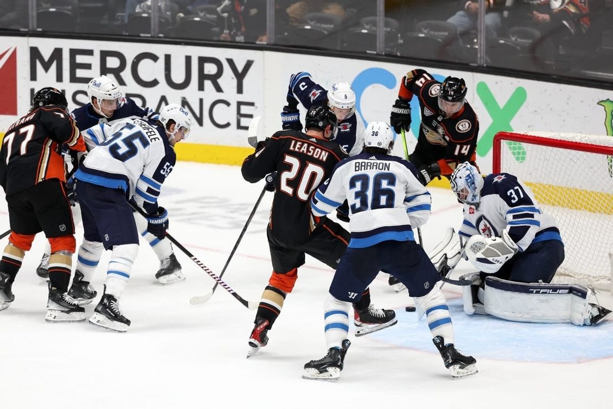 Dec 10, 2023; Anaheim, California, USA;  Winnipeg Jets goaltender Connor Hellebuyck (37) defends the goal against Anaheim Ducks right wing Brett Leason (20) during the third period at Honda Center.