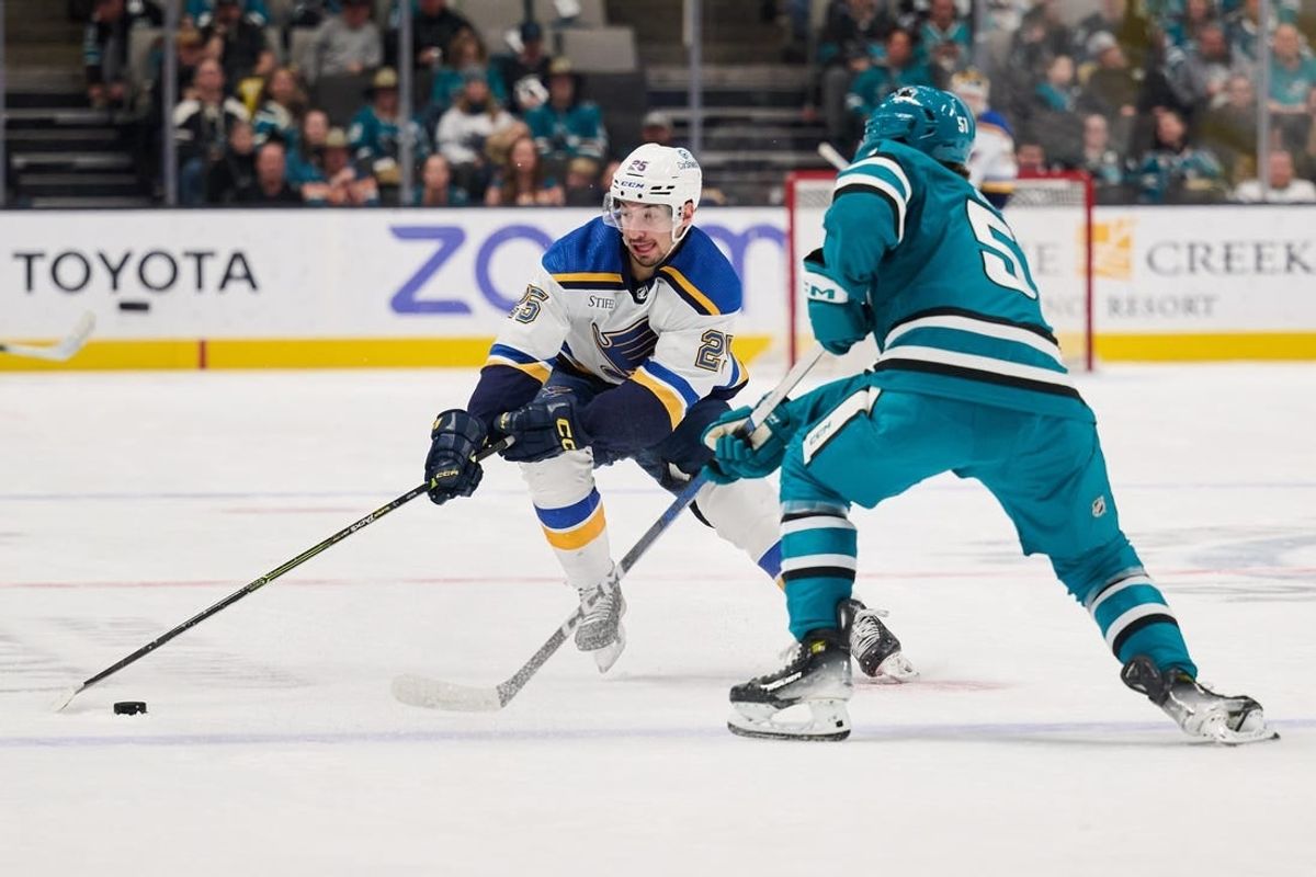 Apr 6, 2024; San Jose, California, USA; St. Louis Blues center Jordan Kyrou (25) plays the puck against San Jose Sharks right wing Collin Graf (51) during the first period at SAP Center at San Jose.
