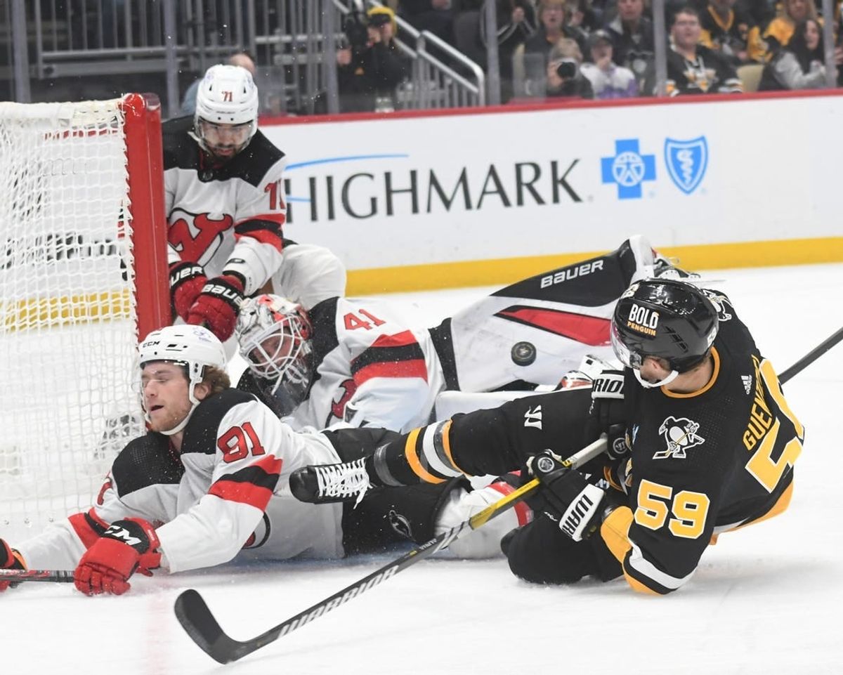 Nov 16, 2023; Pittsburgh, Pennsylvania, USA; Pittsburgh Penguins left wing Jake Guentzel (58) crashes into New Jersey Devils goalie Vitek Vanecek (41) and center Dawson Mercer (91) during the first period at PPG Paints Arena.