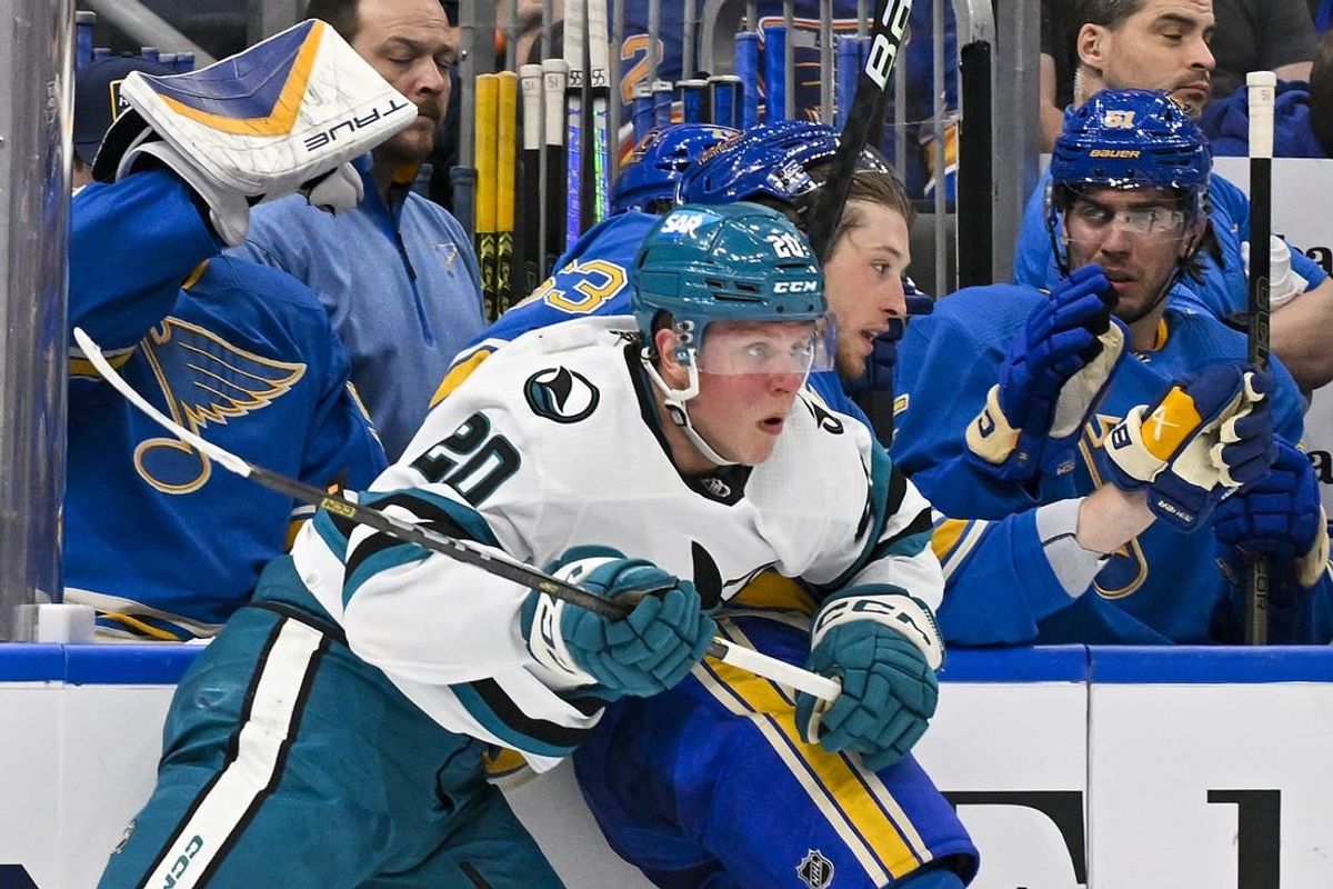 Mar 30, 2024; St. Louis, Missouri, USA;  San Jose Sharks left wing Fabian Zetterlund (20) checks St. Louis Blues left wing Jake Neighbours (63) during the first period at Enterprise Center.
