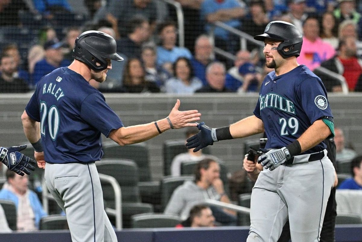 Apr 10, 2024; Toronto, Ontario, CAN;   Seattle Mariners catcher Cal Raleigh (29) is greeted by pinch runner Luke Raley (20) after scoring them both by hitting a two run home run in the 10th inning against the Toronto Blue Jays at Rogers Centre.