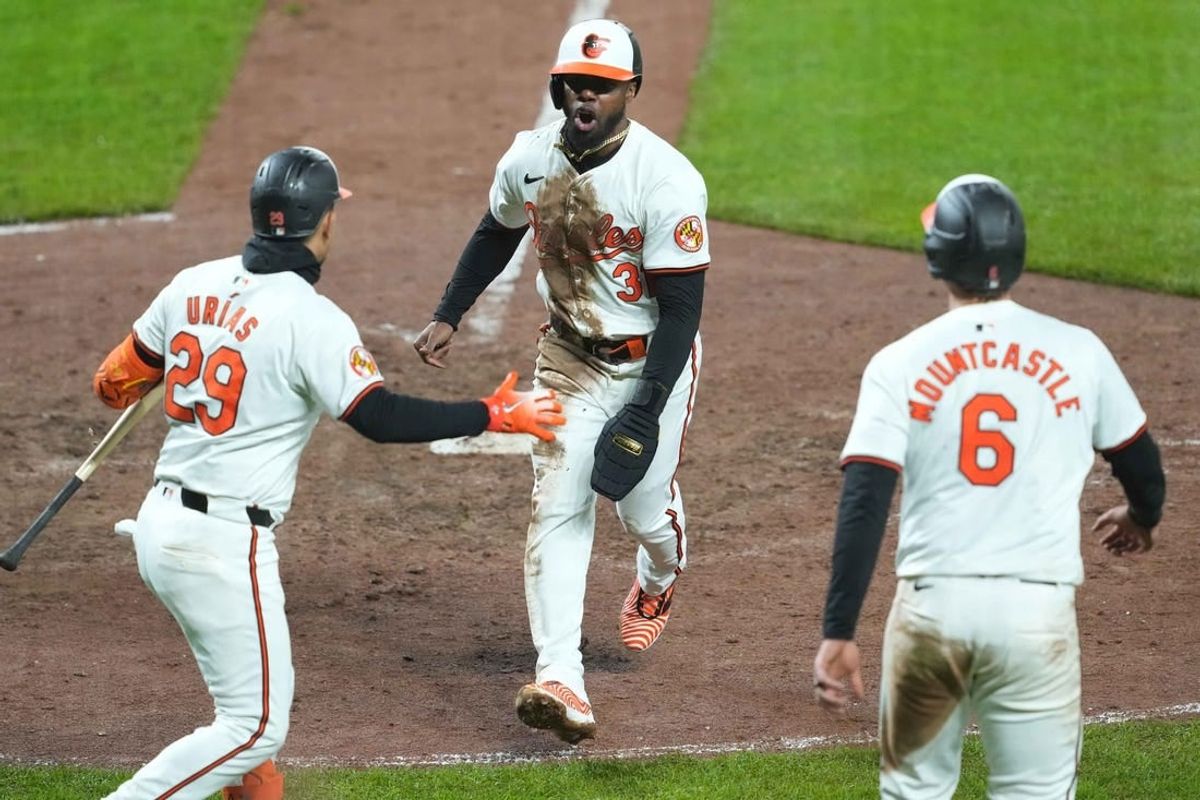 Apr 3, 2024; Baltimore, Maryland, USA; Baltimore Orioles pinch runner Cedric Mullins (31) greeted by third baseman Ramon Arias (29) and first baseman Ryan Mountcastle (6) after scoring the game winning run in the ninth inning against the Kansas City Royals at Oriole Park at Camden Yards.