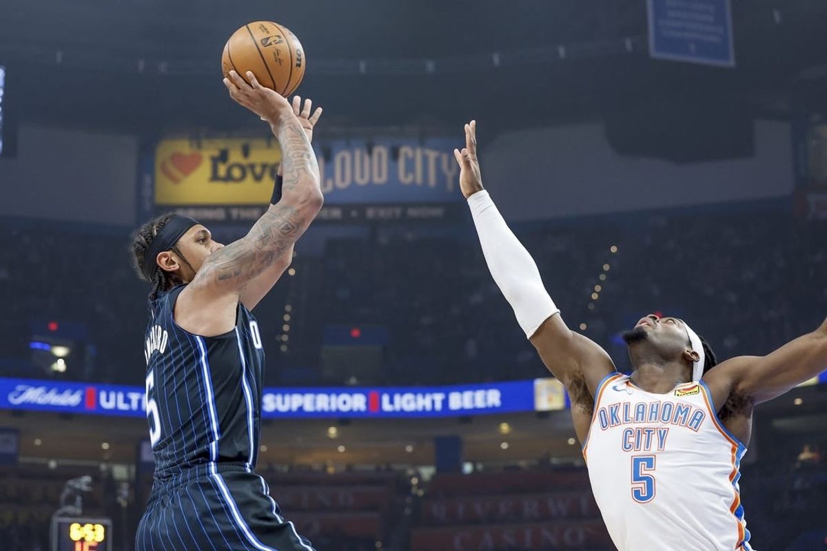Jan 13, 2024; Oklahoma City, Oklahoma, USA; Orlando Magic forward Paolo Banchero (5) shoots as Oklahoma City Thunder guard Luguentz Dort (5) defends during the first quarter at Paycom Center.