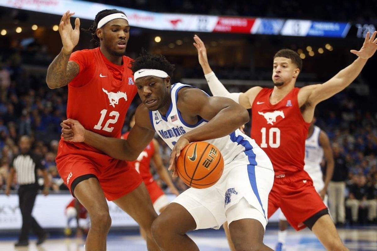 Jan 7, 2024; Memphis, Tennessee, USA; Memphis Tigers forward Malcolm Dandridge (23) dribbles as Southern Methodist Mustangs forward Tyreek Smith (12) and forward Samuell Williamson (10) defend during the first half at FedExForum.
