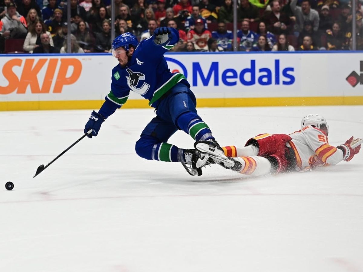 Mar 23, 2024; Vancouver, British Columbia, CAN; Vancouver Canucks forward J.T. Miller (9) checked by Calgary Flames defenseman Olivver Kylington (58) during the third period at Rogers Arena.
