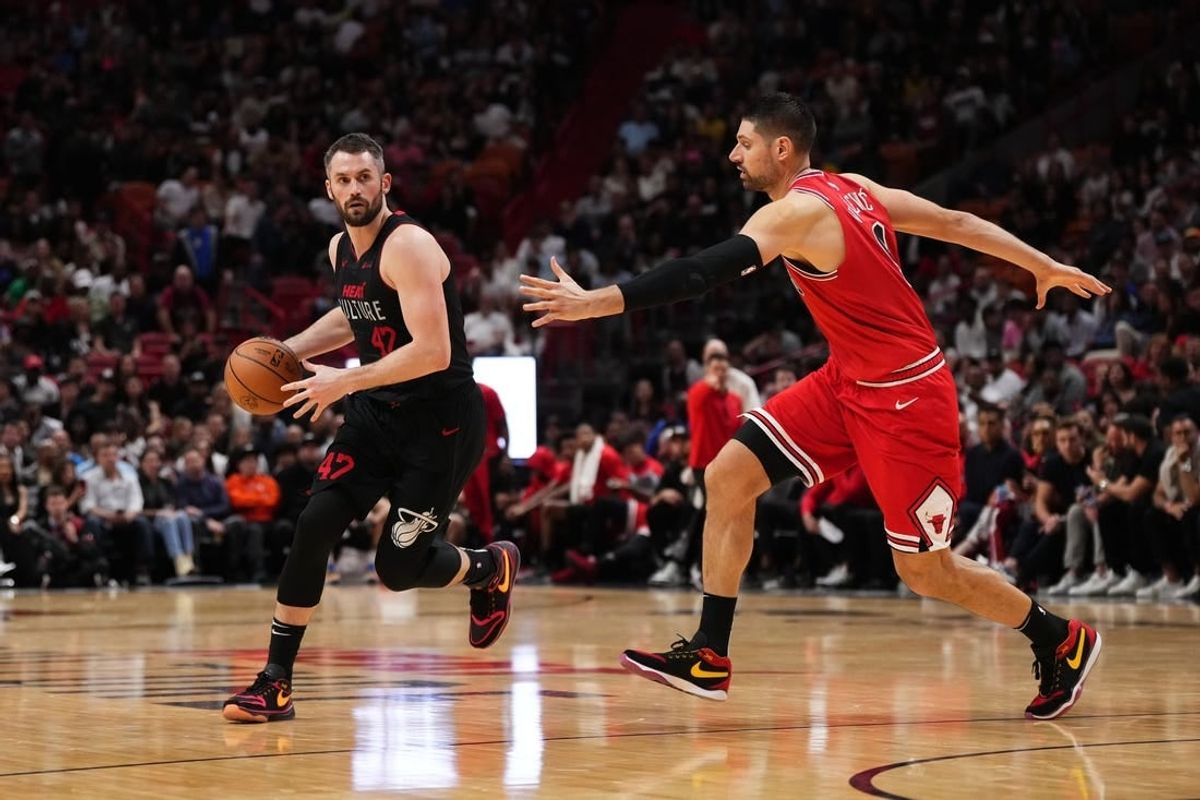 Dec 16, 2023; Miami, Florida, USA; Miami Heat forward Kevin Love (42) dribbles the ball around Miami Heat guard Dru Smith (9) during the second half at Kaseya Center.