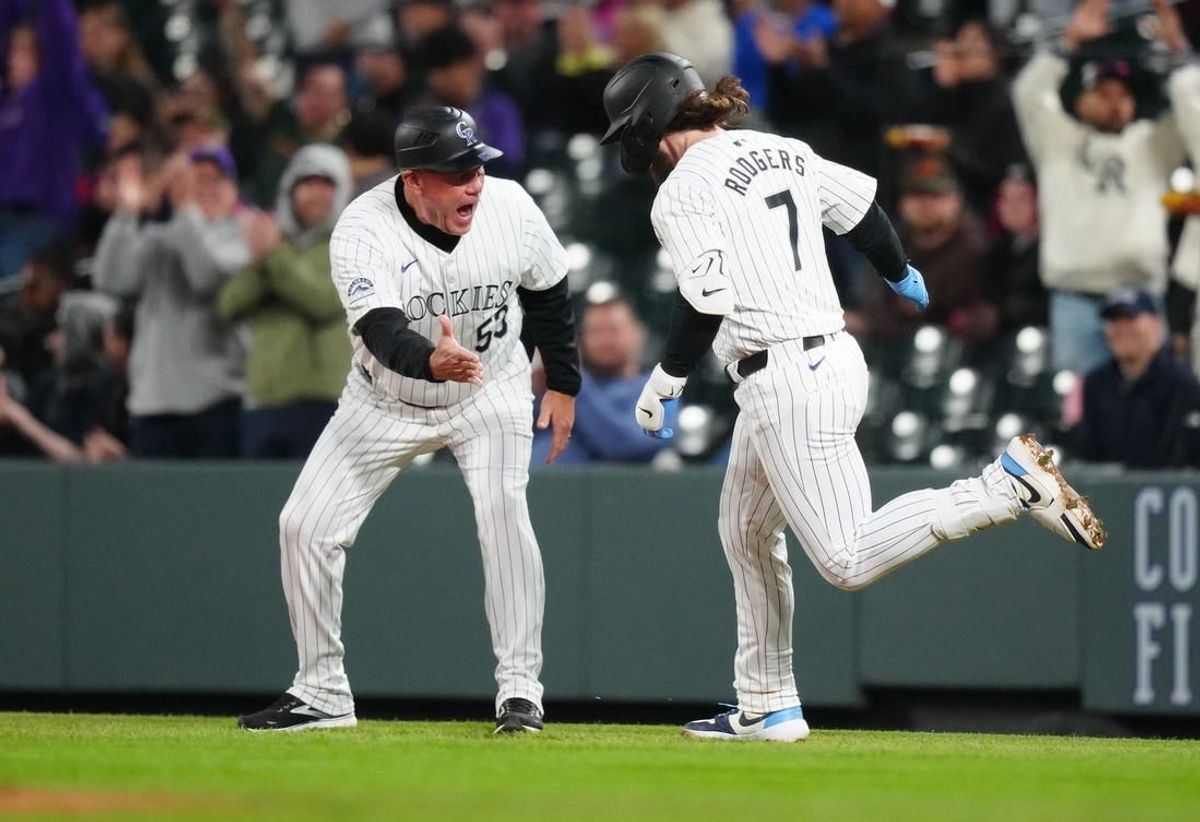 Apr 23, 2024; Denver, Colorado, USA; Colorado Rockies second base Brendan Rodgers (7) is congratulated by first base coach Ronnie Gideon (53) for his grand slam in the fourth inning against the San Diego Padres at Coors Field.