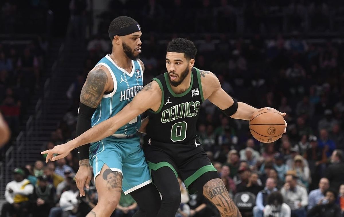 Nov 20, 2023; Charlotte, North Carolina, USA; Boston Celtics forward Jayson Tatum (0) looks to drive past Charlotte Hornets forward Miles Bridges (0) during the first half at the Spectrum Center.