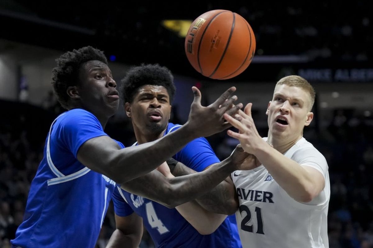 Dec 23, 2023; Cincinnati, Ohio, USA;  Seton Hall Pirates guard Kadary Richmond, left, center Elijah Hutchins-Everett, middle, and Xavier Musketeers forward Sasa Ciani, right, battle for a rebound in the first half at the Cintas Center.