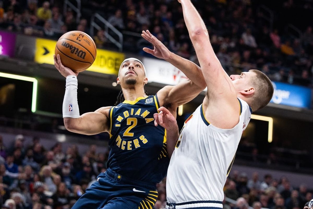 Jan 23, 2024; Indianapolis, Indiana, USA; Indiana Pacers guard Andrew Nembhard (2) shoots the ball while Denver Nuggets center Nikola Jokic (15) defends in the first half at Gainbridge Fieldhouse.