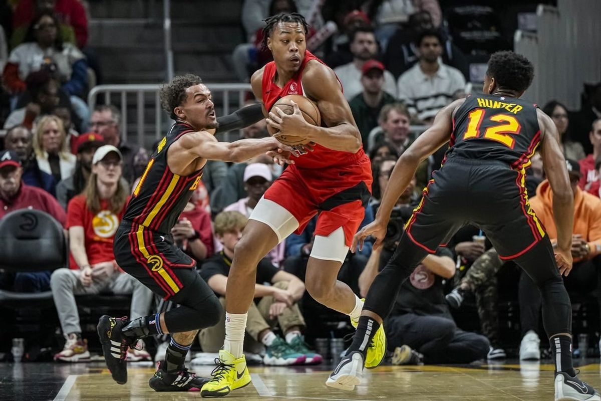 Feb 23, 2024; Atlanta, Georgia, USA; Toronto Raptors forward Scottie Barnes (4) holds the ball defended by Atlanta Hawks guard Trae Young (11) during the first half at State Farm Arena.