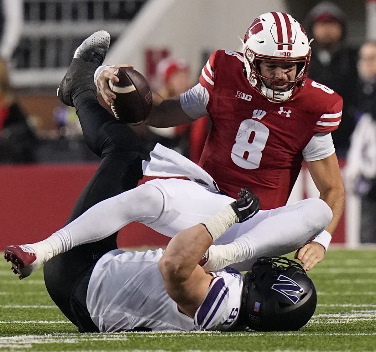 Nov 11, 2023; Madison, Wisconsin, USA; Wisconsin quarterback Tanner Mordecai (8) is sacked by Northwestern defensive lineman Aidan Hubbard (91) during the third quarter at Camp Randall Stadium.