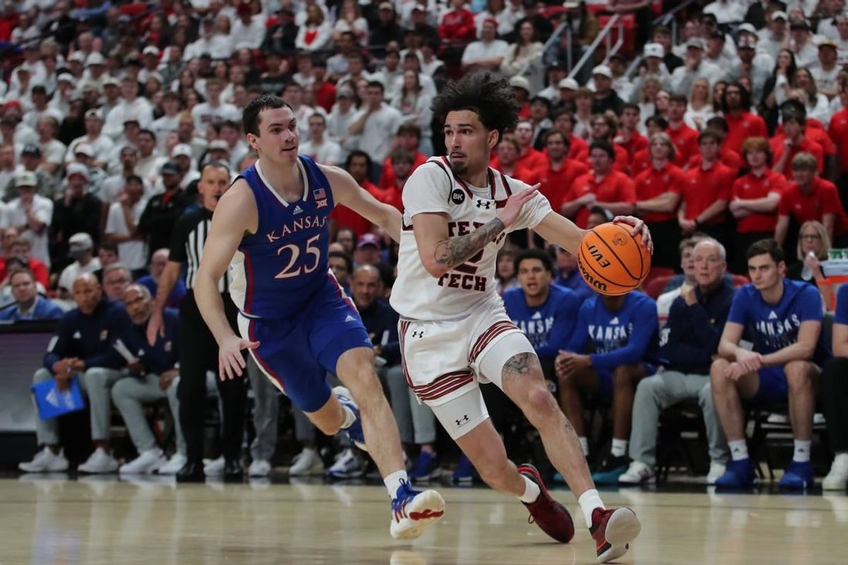 Feb 12, 2024; Lubbock, Texas, USA;  Texas Tech Red Raiders guard Pop Isaacs (2) drives to the lane against Kansas Jayhawks guard Nicolas Timberlake (25) in the first half at United Supermarkets Arena.