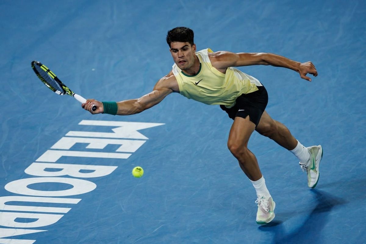 Jan 16, 2024; Melbourne, Victoria, Australia;   Carlos Alcaraz of Spain hits a shot against Richard Gasquet of France in the first round of the men s singles at the Australian Open.