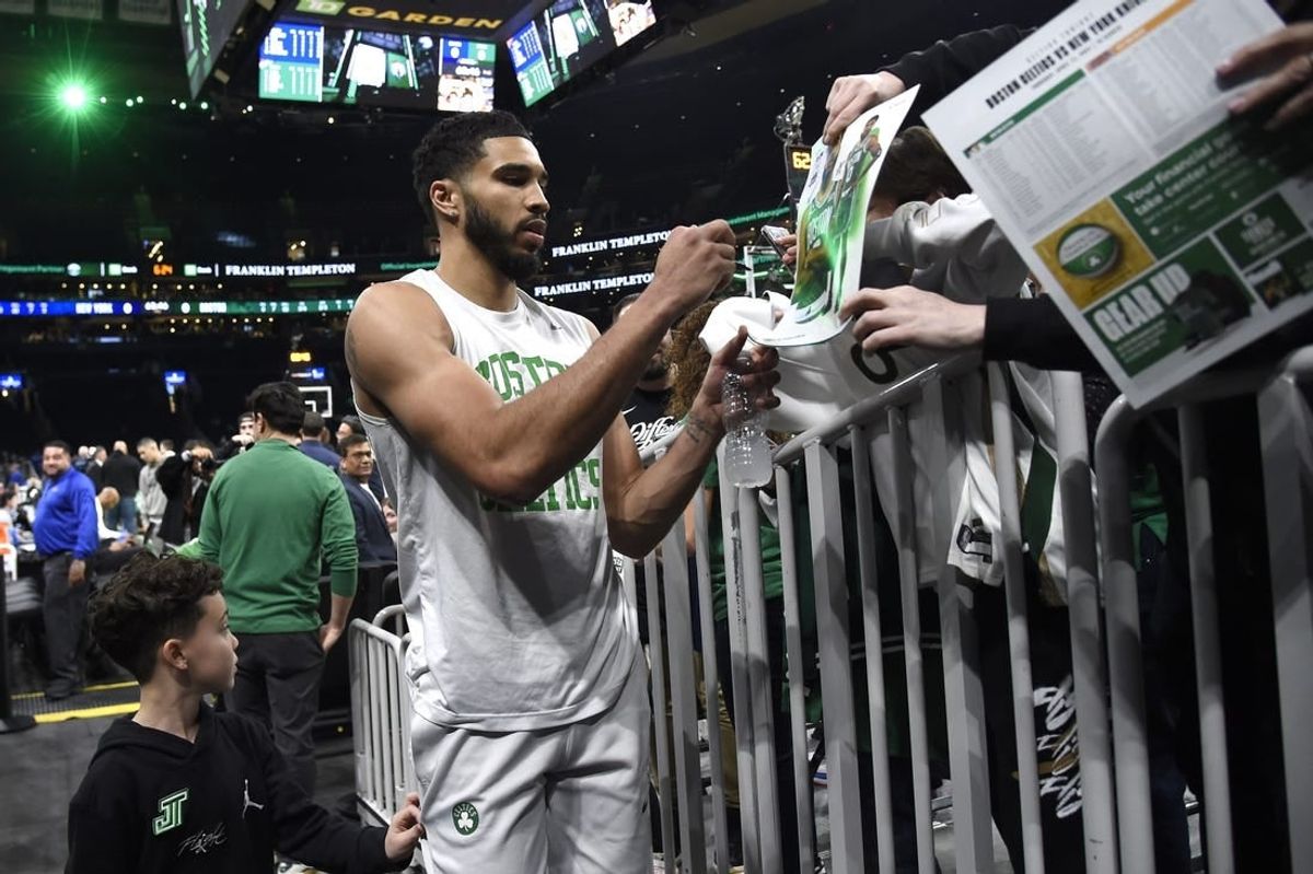 Apr 11, 2024; Boston, Massachusetts, USA;  Boston Celtics forward Jayson Tatum (0) signs an autograph for a fan prior to a game against the New York Knicks at TD Garden.