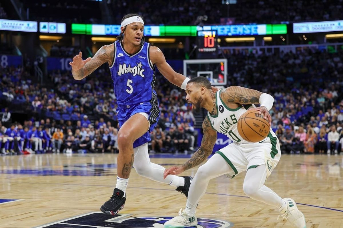 Apr 14, 2024; Orlando, Florida, USA; Milwaukee Bucks guard Damian Lillard (0) moves the ball against Orlando Magic forward Paolo Banchero (5) during the first quarter at KIA Center.