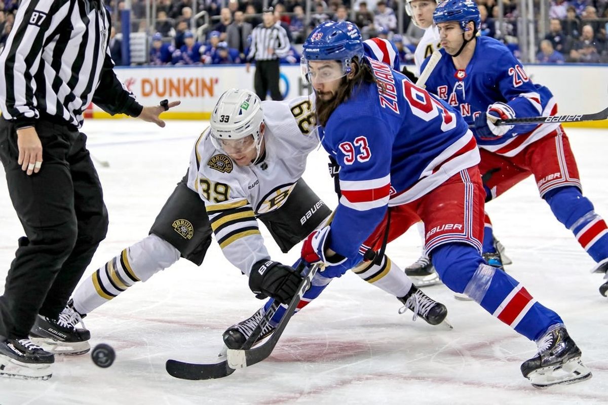Nov 25, 2023; New York, New York, USA; Boston Bruins center Morgan Geekie (39) and New York Rangers center Mika Zibanejad (93) battle for the puck after a face-off during the first period at Madison Square Garden.