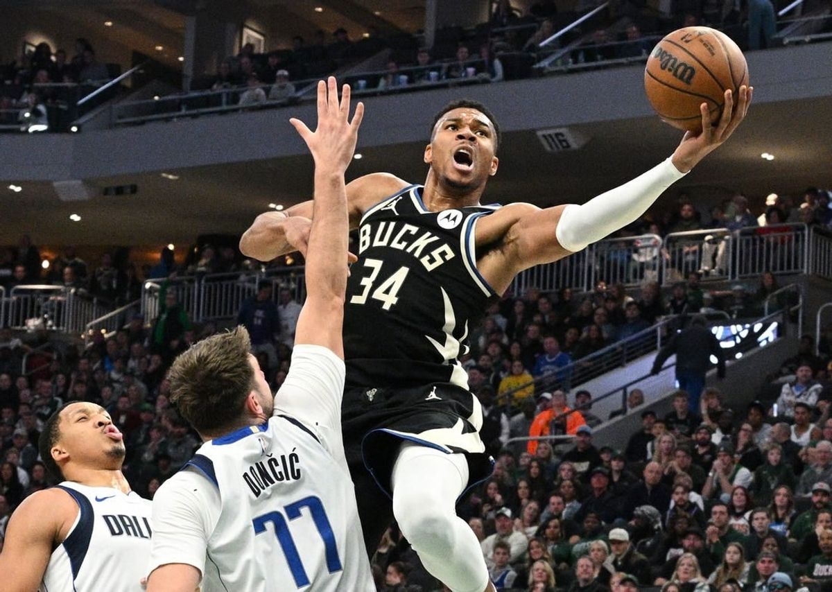 Nov 18, 2023; Milwaukee, Wisconsin, USA; Milwaukee Bucks forward Giannis Antetokounmpo (34) drives to the basket against Dallas Mavericks guard Luka Doncic (77) in the first half at Fiserv Forum.