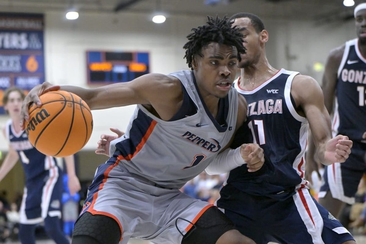Jan 18, 2024; Malibu, California, USA; Pepperdine Waves guard Michael Ajayi (1) is defended by Gonzaga Bulldogs guard Nolan Hickman (11) in the second half at Firestone Fieldhouse.