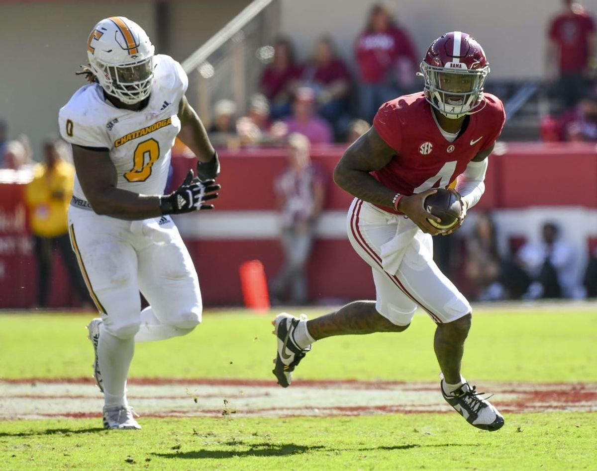 Nov 18, 2023; Tuscaloosa, Alabama, USA;  Alabama Crimson Tide quarterback Jalen Milroe (4) rolls out with Chattanooga Mocs defensive lineman Quay Wiggles (0) giving chase at Bryant-Denny Stadium.