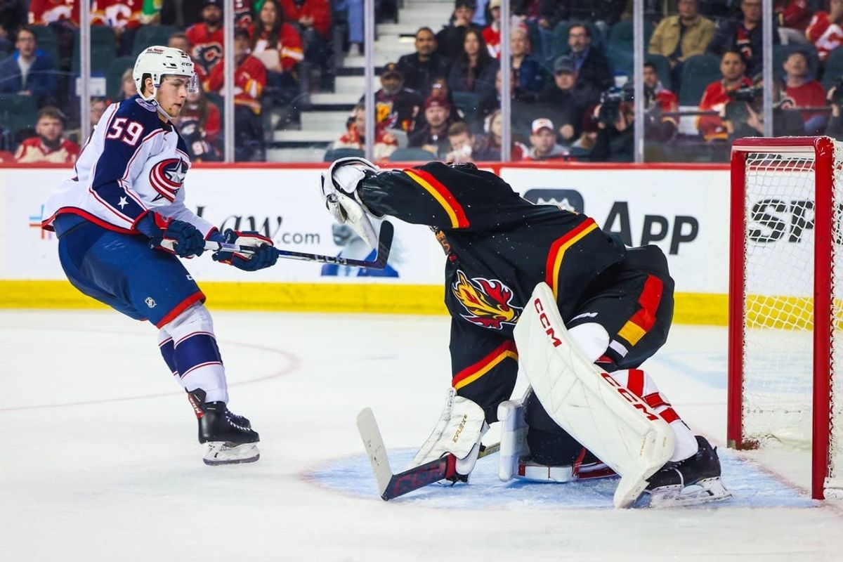 Jan 25, 2024; Calgary, Alberta, CAN; Calgary Flames goaltender Jacob Markstrom (25) makes a save against Columbus Blue Jackets right wing Yegor Chinakhov (59) during the second period at Scotiabank Saddledome.