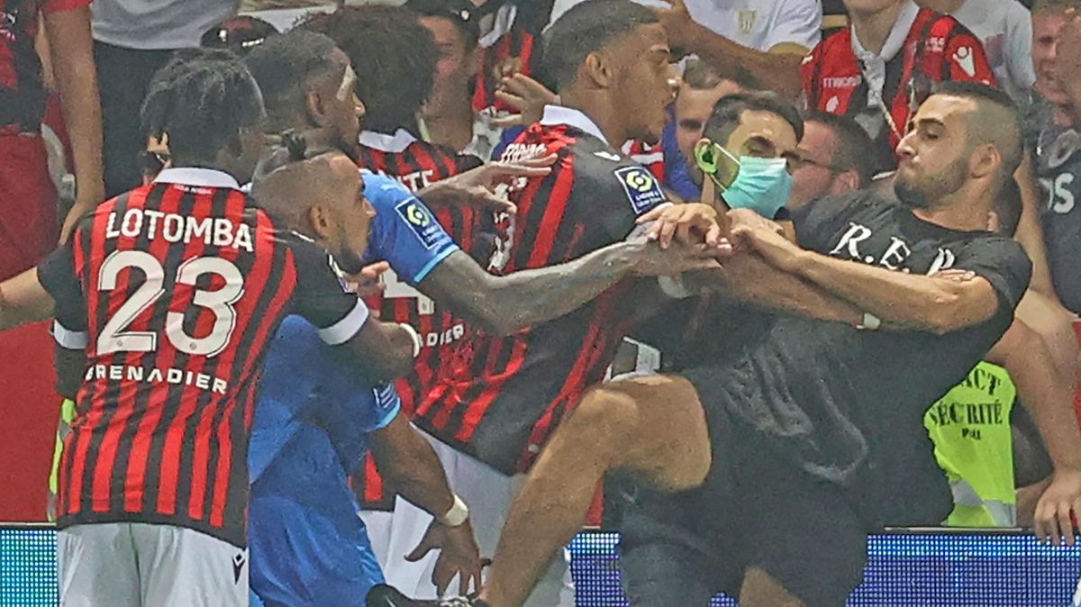 Marseille’s  French  midfielder  Dimitri  Payet  (2nd  L)  reacts  as  players  from  OGC  Nice  and  Olympique  de  Marseille   stop  a  fan  invading  the  pitch  trying  to  kick  Payet  during a   French  L1  football  match.