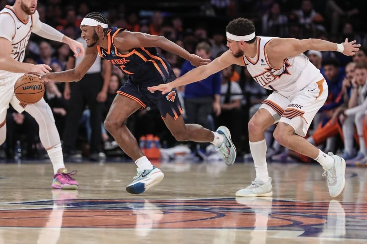 Nov 26, 2023; New York, New York, USA; New York Knicks guard Immanuel Quickley (5) steals the ball from Phoenix Suns guard Devin Booker (1) in the fourth quarter at Madison Square Garden.