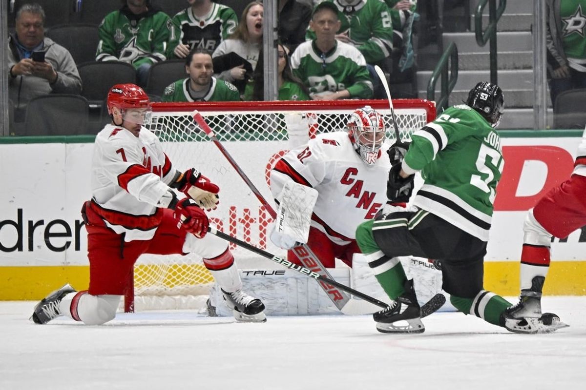 Feb 13, 2024; Dallas, Texas, USA; Carolina Hurricanes defenseman Dmitry Orlov (7) and goaltender Pyotr Kochetkov (52) face a shot by Dallas Stars center Wyatt Johnston (53) during the first period at the American Airlines Center.