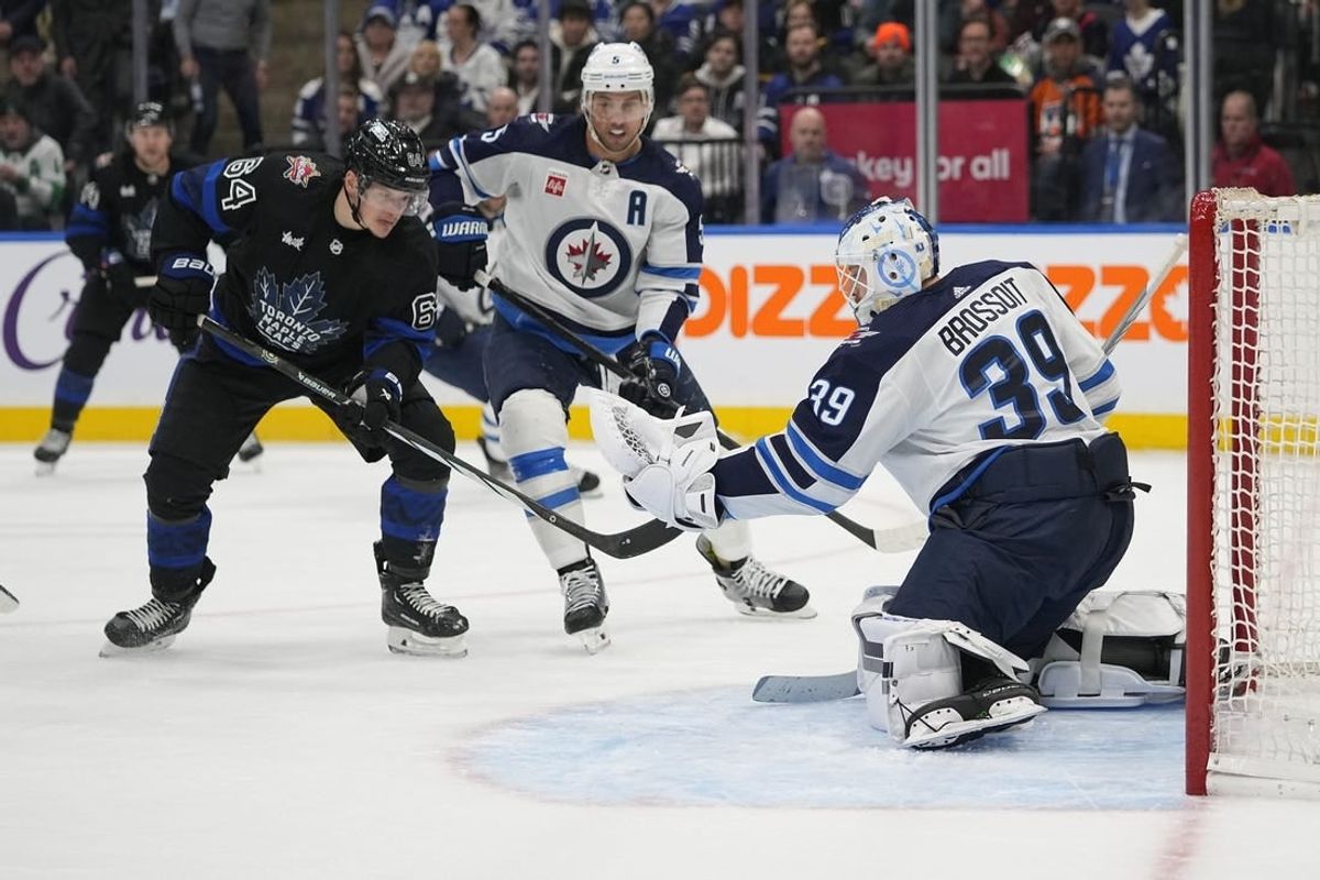 Jan 24, 2024; Toronto, Ontario, CAN; Winnipeg Jets goaltender Laurent Brossoit (39) makes a save as  Toronto Maple Leafs forward David Kampf (64) looks for a rebound during the first period at Scotiabank Arena.