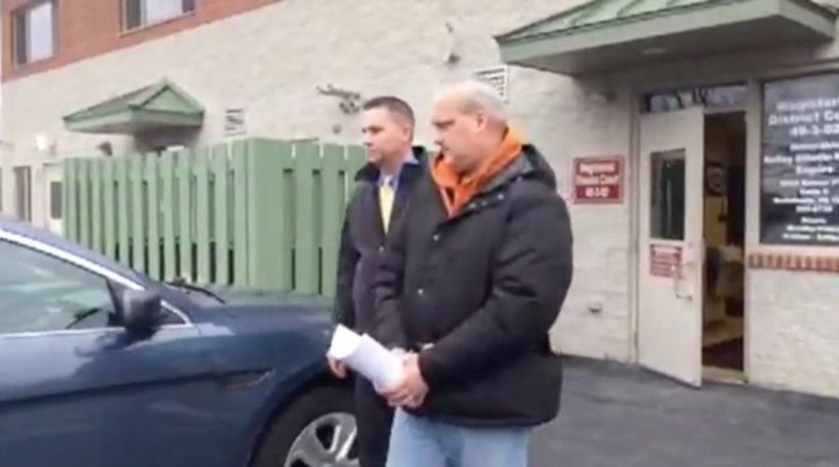 Jeffrey Sandusky (orange collar) is led out of court in handcuffs. Image:  [object Object]