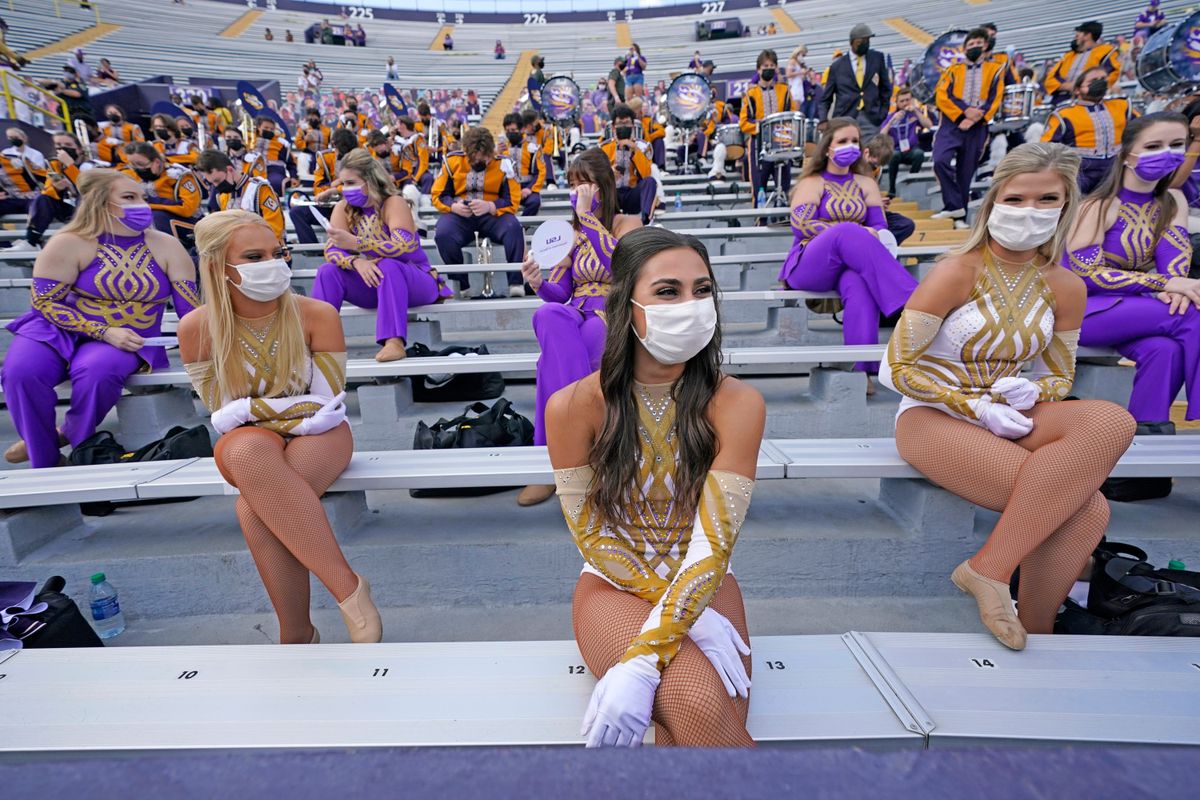 The LSU Golden Girls dance team sit spaced apart wearing masks before a game between the Tigers and the Mississippi State.