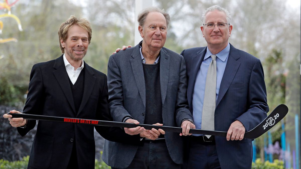 Seattle part-owners Jerry Bruckheimer, left, and David Bonderman, center, with president/CEO Tod Leiweke and a hockey stick.