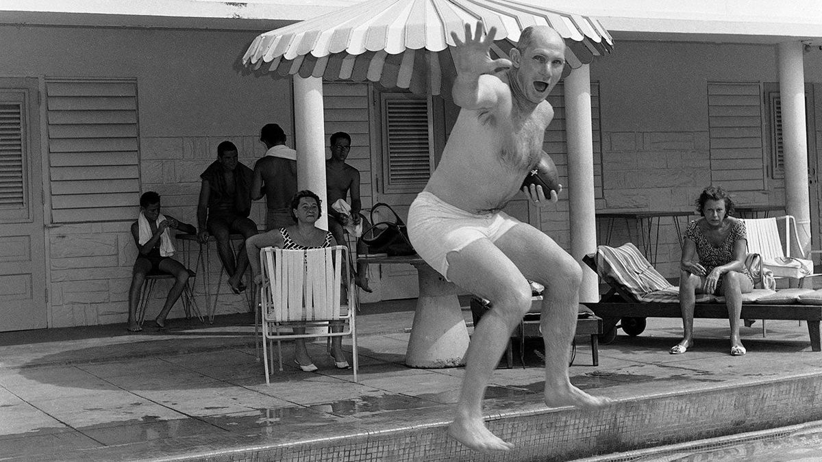 The original Associated Press caption for this photo: “Y.A. Tittle, quarterback for the New York Football Giants who is best known for his passing, carries the ball as he jumps into pool during the ball as he jumps into pool during vacation at San Juan, Puerto Rico on May 8, 1964. Tittle is one of a contingent of Giants visiting Puerto Rico to teach football to the natives.”