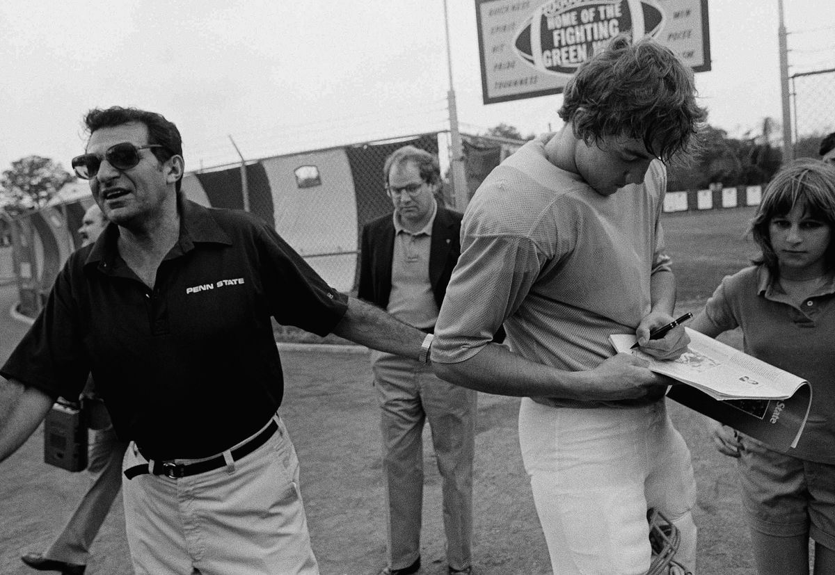 Joe Paterno tries to pull Todd Blackledge away from signing autographs in 1982. Jack Thornell/ [object Object]