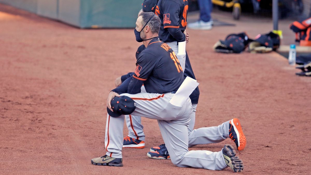 San Francisco Giants manager Gabe Kapler takes a knee Sunday.