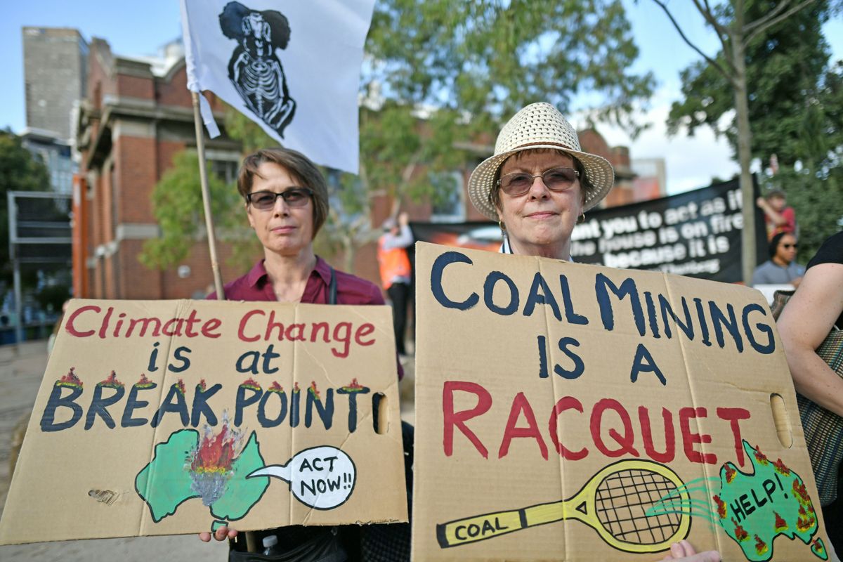 Demonstrators hold up placards outside the Australian Open venue during a climate protest rally in Melbourne on January 24, 2020.