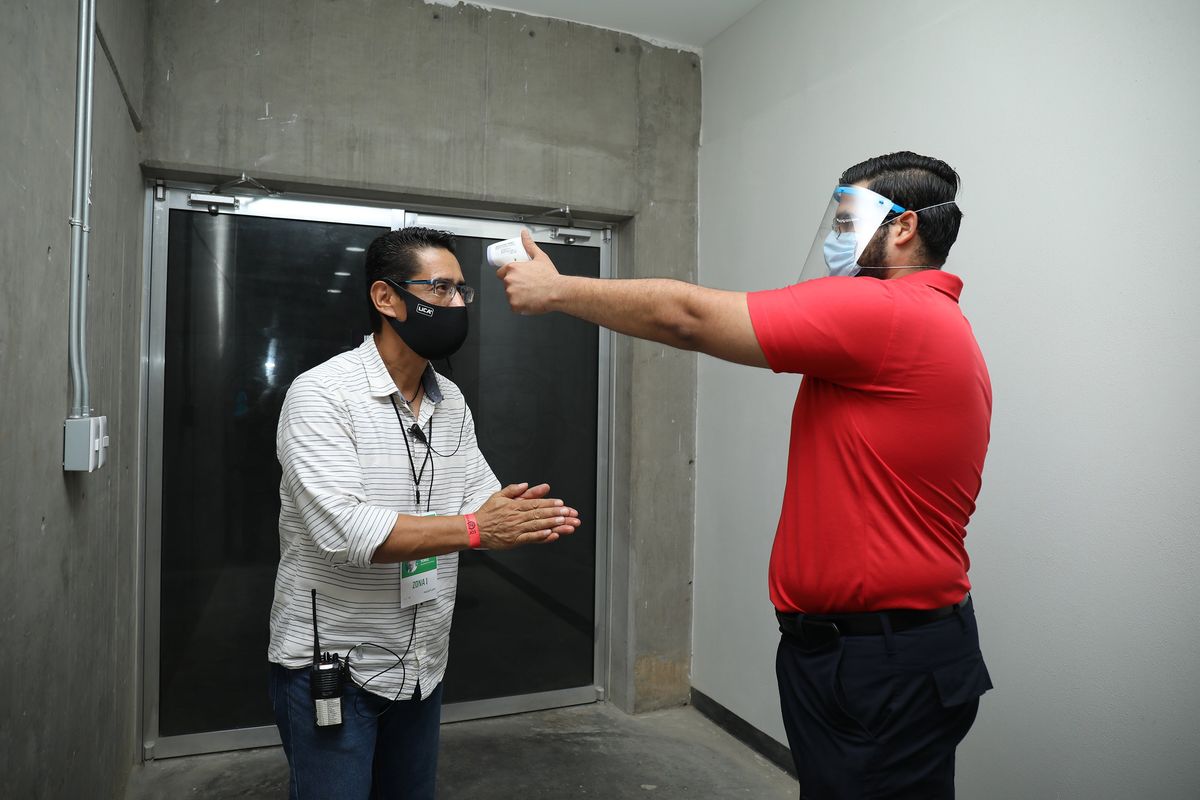 A paramedic measures the temperature of a press staffer at a Liga MX match Friday in Mazatlan, Mexico.