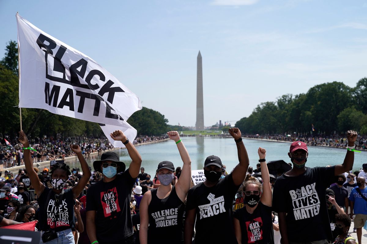 Attendees raise their fists while participating in the March on Washington at the Lincoln Memorial Friday, marking the 57th anniversary of Rev. Martin Luther King Jr.’s “I Have A Dream” speech there.