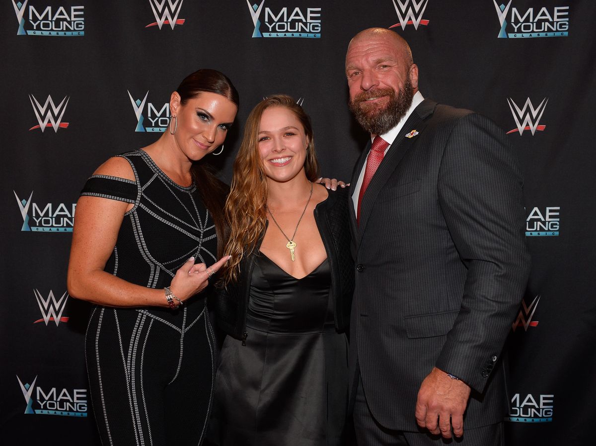 Ronda Rousey photographed with two large fans.